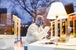 © tunedin - Mature man sitting at desk in a library in the evening using laptop