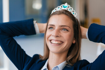 Ambitious young woman wearing crown as an award for her achievments