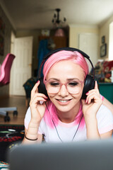 Sticker - Young woman with pink hair listening to music via laptop at home