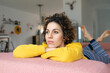 © tunedin - Woman lying on couch at home thinking
