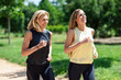 © tunedin - Mature woman running with her daughter in a park