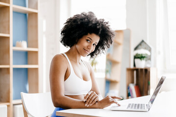 Poster - Fit young woman using laptop at home