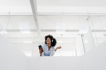 Poster - Happy young woman listening to music in office