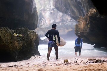 Wall Mural - Indonesia, Bali, back view of surfer carrying surfboard