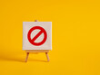© Cagkan - A canvas with no entry sign on an easel with yellow background with copy space.
