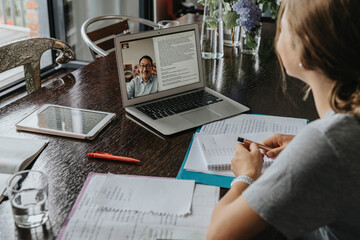 Teenage girl studying from home, using laptop