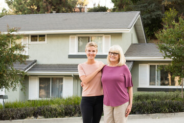 Wall Mural - Portrait of smiling woman with mother in front of a house