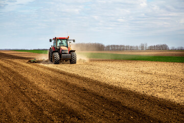 Wall Mural - Farmer in tractor plowing field in spring