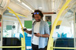 © tunedin - Young trendy man smiling while using smart phone in train