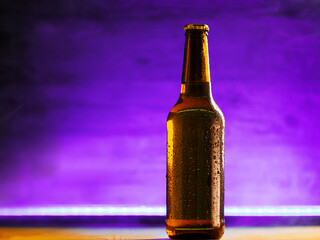 Wall Mural - A cold beer bottle on a purple background, copy space