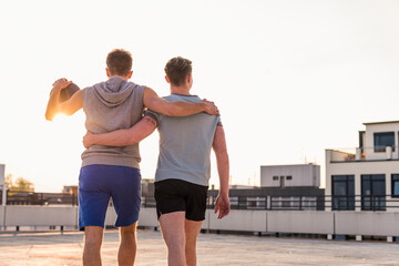 Wall Mural - Friends playing basketball at sunset on a rooftop