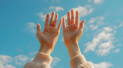 Two hands reaching up towards the sky, with a blue sky in the background