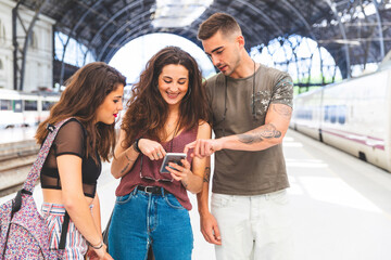 Wall Mural - Friends with cell phone on train station platform