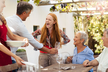 Wall Mural - Happy family setting table outside for lunch