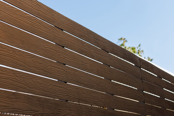 Wall Mural - A wooden fence with a blue sky in the background