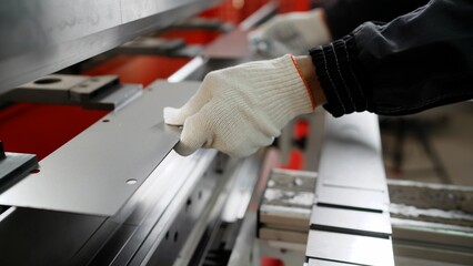 Man working with sheet metal and special machine tools for bending. Modern machines can accurately perform tasks.