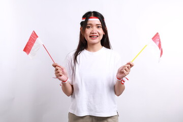 Smiling young Asian woman with red white flag and ribbon holding flag indonesian to celebrating indonesian independence day on 17 august isolated on white background