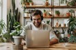 © Sandu - Man smiling headphones sitting table laptop