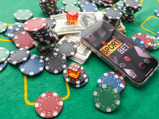 Wall Mural - Online poker concept. Smartphone and poker chips on a green background. Poker online banner. Copy space. Vignette. Place for text. Gambling. Background