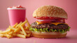 © ShniDesign - Close up burger and fries isolated on pink pastel background. Concept of ultra processed food.