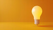 © Clemency - yellow light bulb on golden yellow background with copy space
