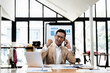 © aksonsat - Businessman is talking to clients and colleague on the phone are excited and happy to success and achievement on business financial and marketing and working on laptop in the office