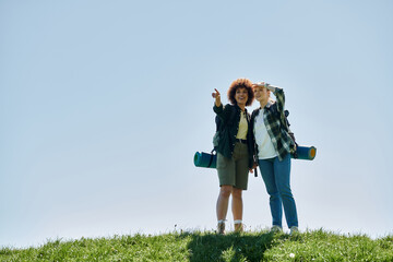 Wall Mural - A young lesbian couple hikes through the wilderness, enjoying a sunny day together.