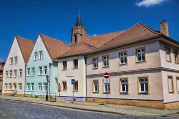 Sticker - beeskow, deutschland - sanierte häuserzeile und turm der marienkirche