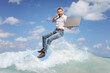 © Ljupco Smokovski - Businessman on a surfboard in the sea using a smartphone and holding a laptop