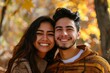 © Markus Schröder - Portrait of a grinning latino couple in their 20s dressed in a comfy fleece pullover over background of autumn leaves