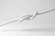 © Dragon Claws - White knot of a rope floating in mid air on white background in monochrome and minimalism. Illustration of the concept of problems, difficulties, trouble and obstacles