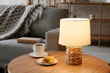 Wall Mural - Glowing lamp on table in interior of living room, closeup
