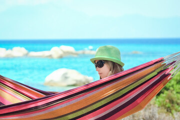 Wall Mural - happy child by the sea on hammock in greece background