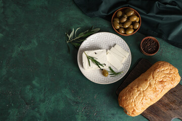 Wall Mural - Plate with tasty feta cheese, rosemary and olive on green background