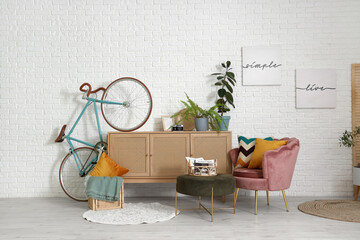 Wall Mural - Light living room with pink armchair, pillows, chest of drawers and bicycle