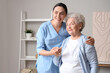 © Pixel-Shot - Senior woman with physical therapist hugging at home