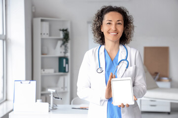 Canvas Print - Mature female doctor with tablet computer in clinic