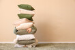 © Pixel-Shot - Young woman with stack of soft pillows in stylish room