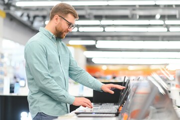 Wall Mural - Man buying laptop at electronic store