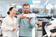 © Serhii - Couple buying wireless vacuum cleaner at store