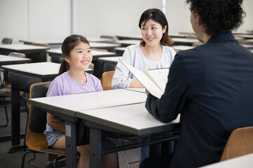 Wall Mural - 面談を受ける親と子供　小学校の教室での三者面談のイメージ