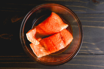 Wall Mural - Marinating Salmon Fillets with Skin Side Down: Raw salmon fillets marinated in a glass mixing bowl with the skin side facing down