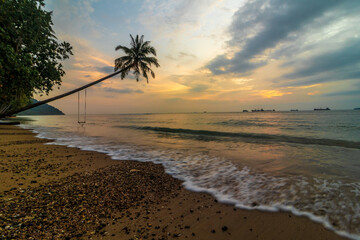 Wall Mural - Beautiful sunset at seaside with silhouette of slanting coconut tree
