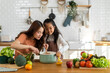 © Art_Photo - Portrait of enjoy happy love asian family mother with little asian girl daughter child help cooking food healthy eat with fresh vegetable testing smell soup in a pot with spoon.helping mom in kitchen