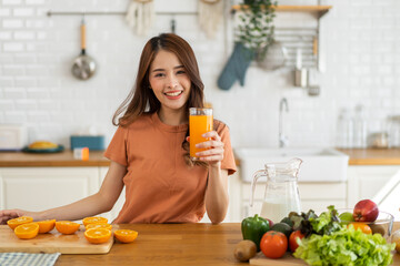 Portrait of beauty healthy asian woman making orange fruit smoothie with blender.girl preparing cooking detox cleanse with fresh orange juice in kitchen at home.health, vitamin c, diet, healthy drink