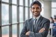 © Stanislav - Successful Indian male businessman. Portrait of attractive young Indian man in business suit and tie standing against modern office background smiling looking at camera