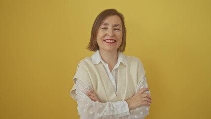 Poster - Happy, middle age hispanic woman standing with crossed arms, looking positive and smiling over yellow isolated background