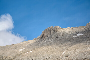 Rocky hill with clouds visible in the background on a sunny day