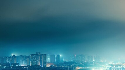 Wall Mural - time lapse of dark clouds over the city buildings at night