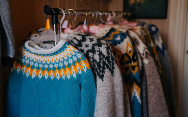 close up of traditional colorful icelandic sweaters for sale. wool knitted lopapeysa sweater. nordic